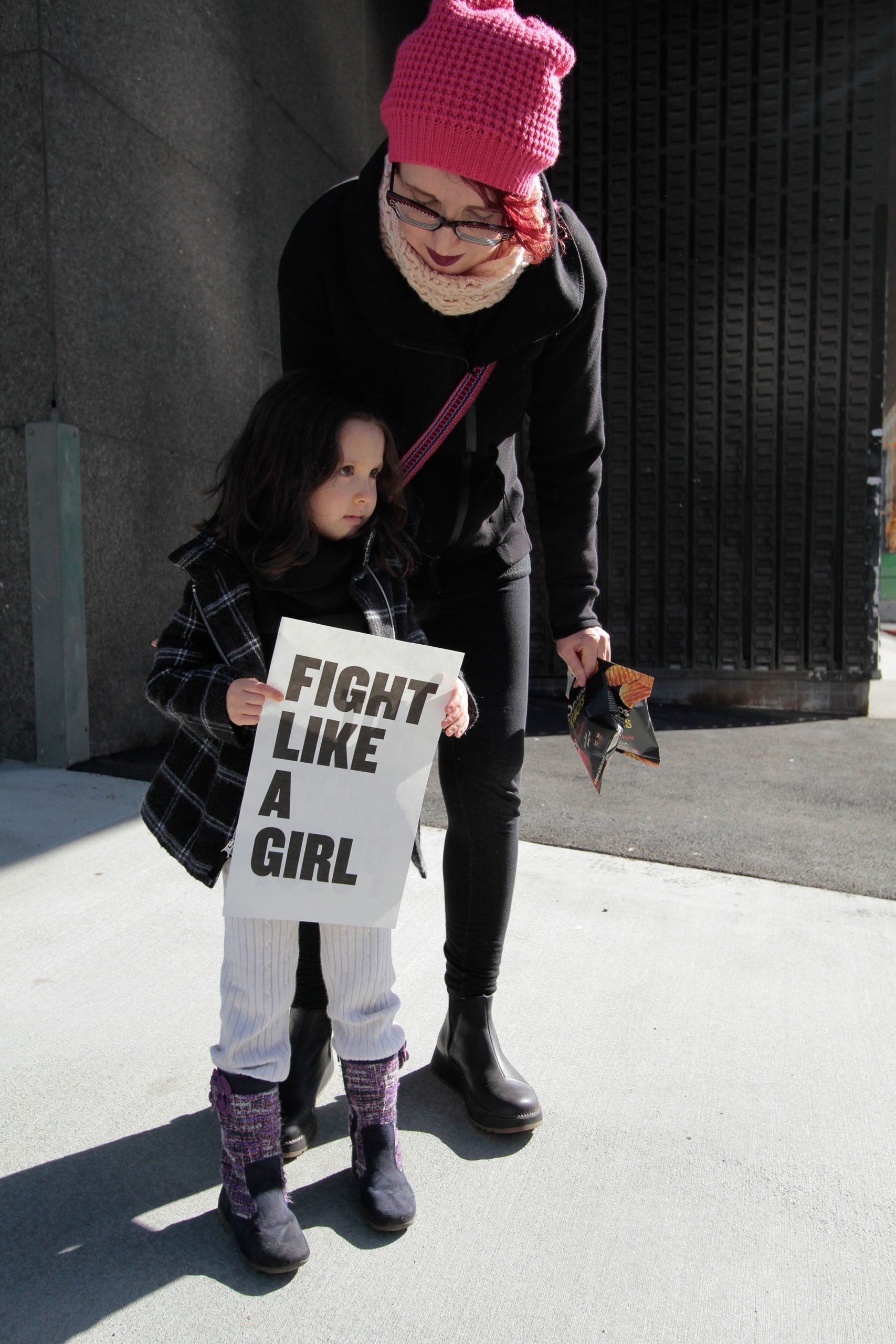 girl holding sign that reads 'Fight like a girl' (link to file)