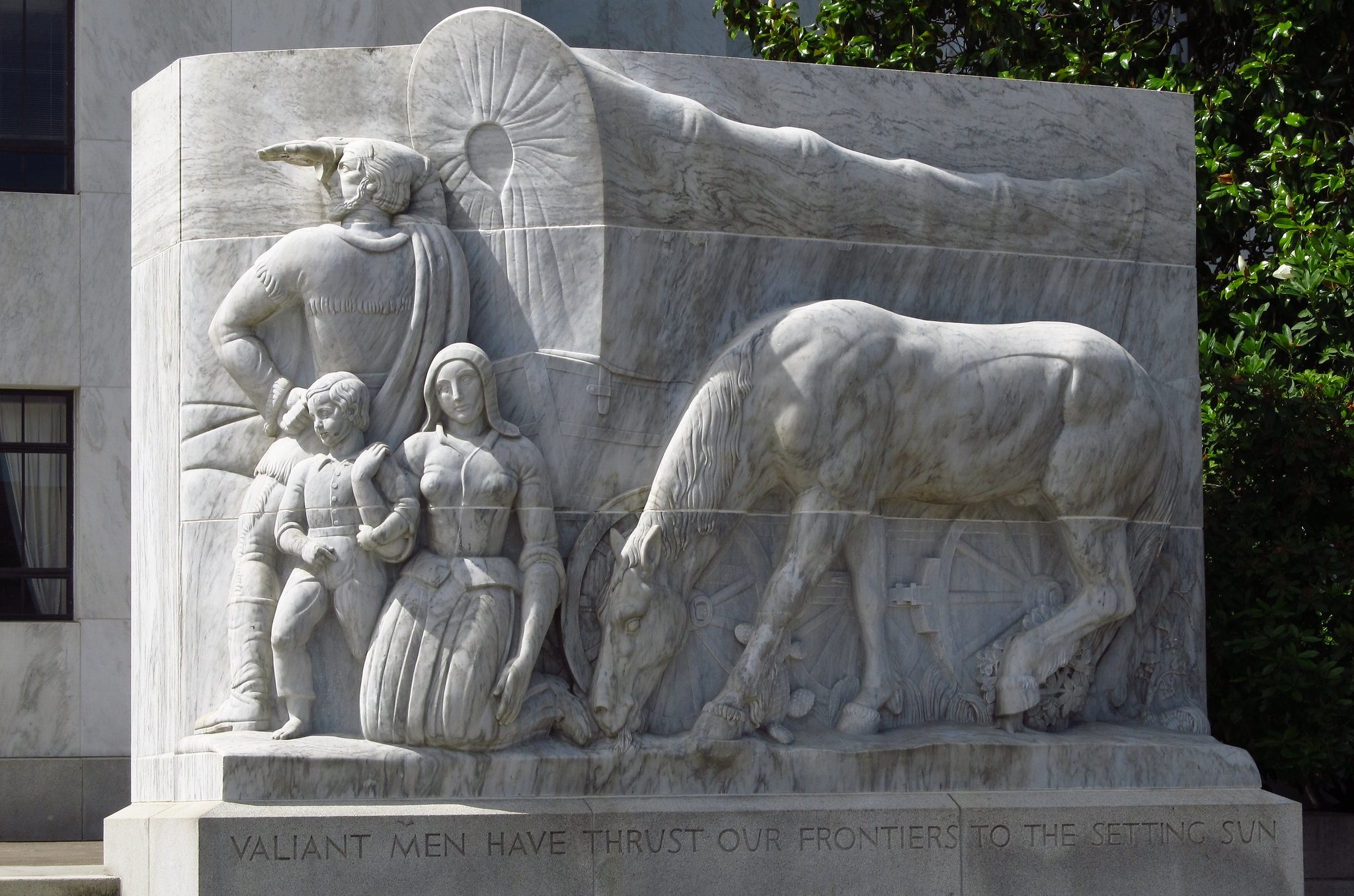 sculpture of settlers that reads 'Valiant men have thrust our frontiers to the setting sun' (link to file)