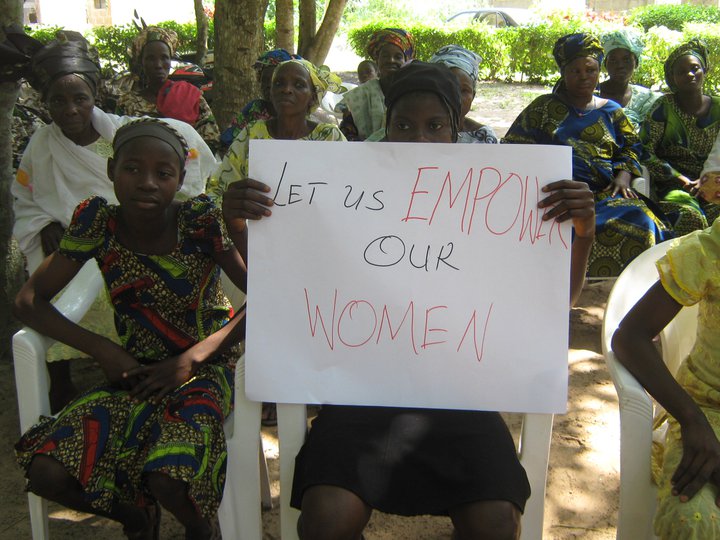 woman with sign that reads 'Let us empower our women' (link to file)