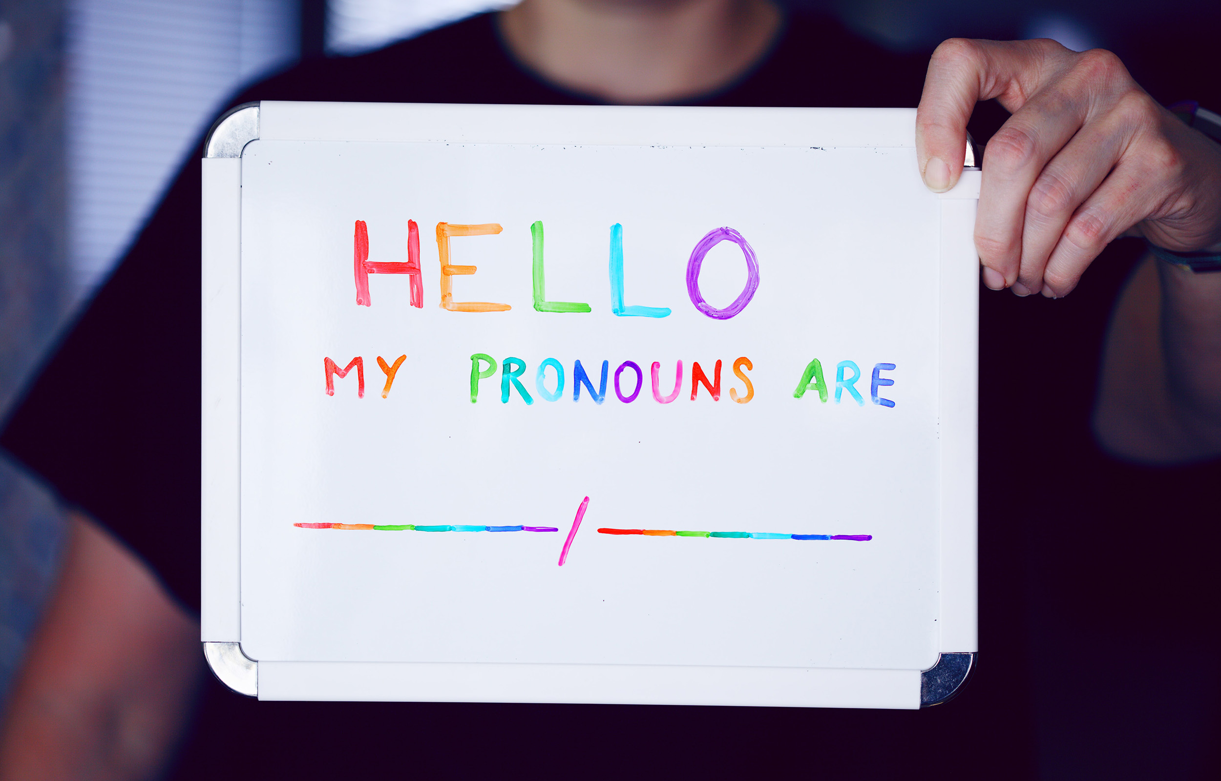 whiteboard that reads in multicolor 'Hello, my pronouns are' (link to file)
