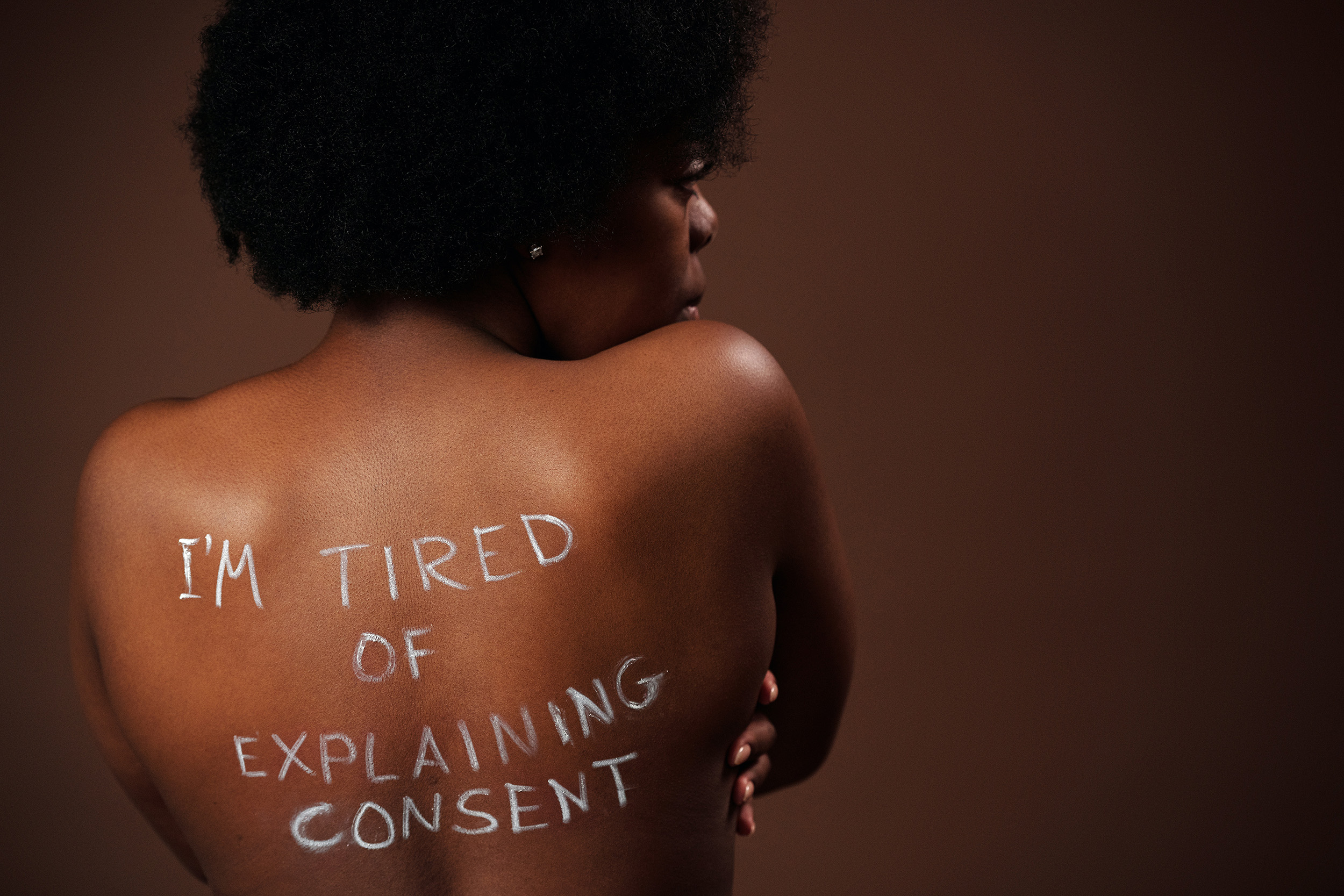 woman with 'I'm tired of explaining consent' written on back (link to file)