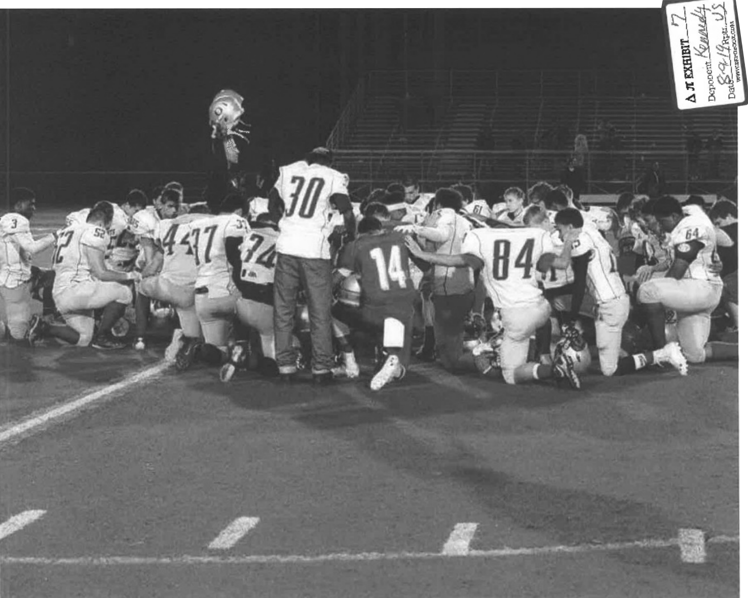 Kneeling football players in football field