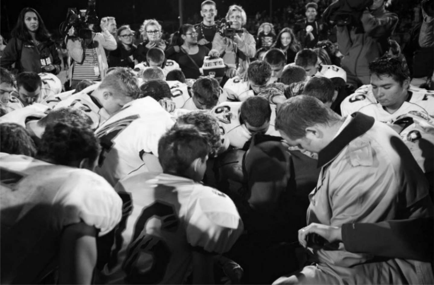 Football players in prayer circle