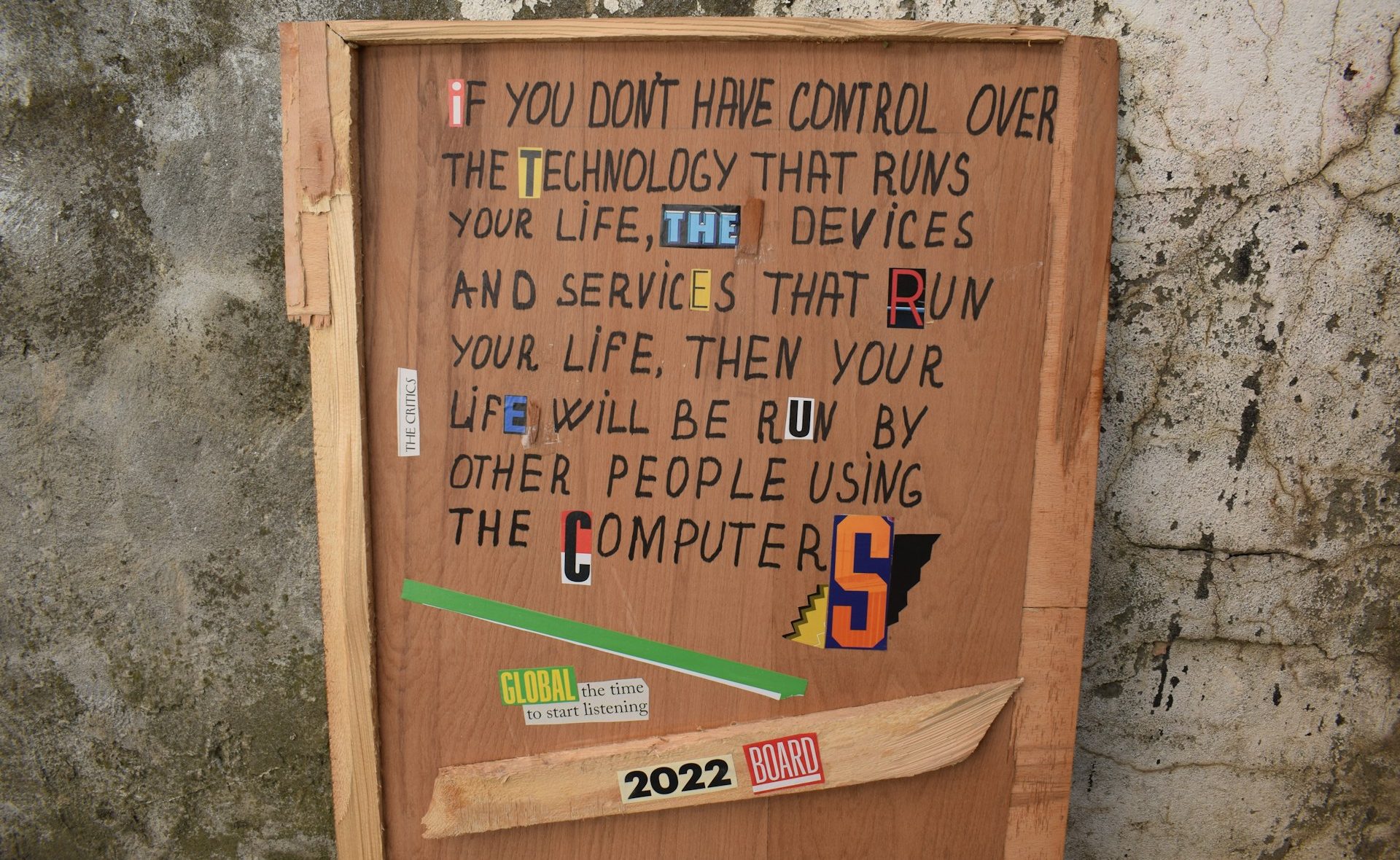 A wooden sign reads, “If you don’t have control over the technology that runs your life . . . your life will be run by other people using the computers”
