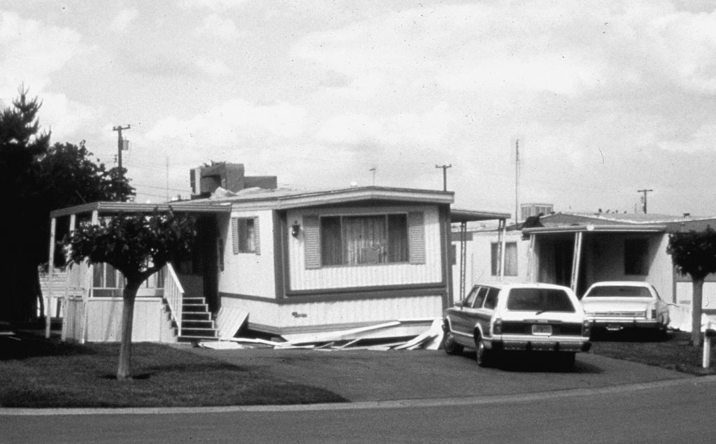 Mobile home has slid off its supports during an earthquake.